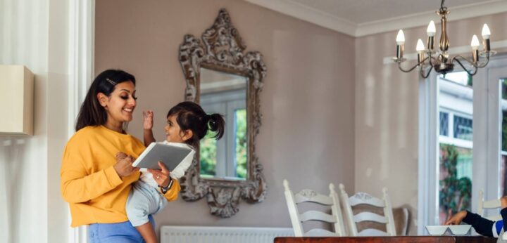 Mother holding her daughter and an ipad.
